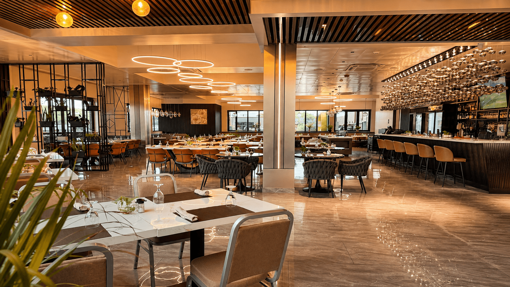 Seaside Haven Restaurant with ring chandeliers, marble tables, and rust leather chairs
