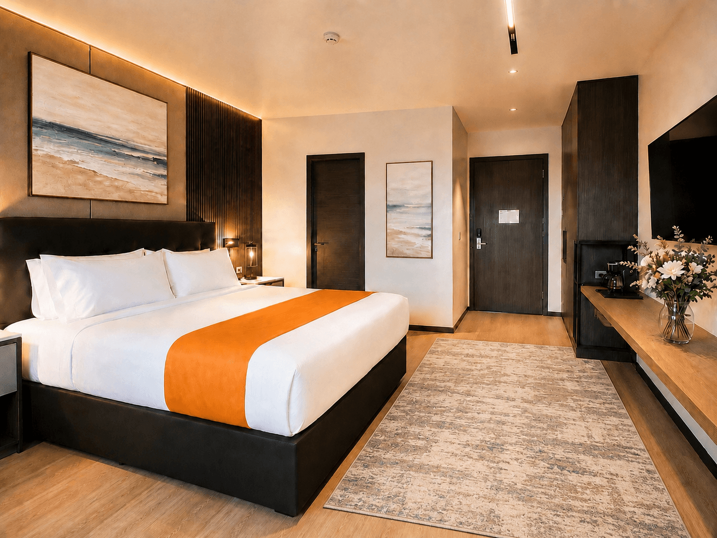 King room with upholstered headboard, soft grey paneling, and warm bedside lamps